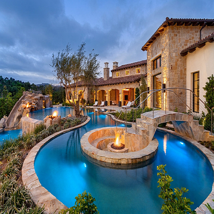 Fire-pit-at-the-heart-of-the-pool-with-sunken-seating-around-it-and-a-beautiful-bridge-leading-the-way